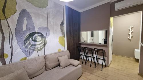 a living room with a couch and a kitchen at Ancora apartment Anja in Novi Sad