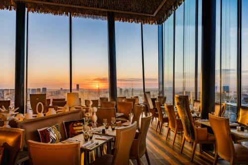 a restaurant with tables and chairs and windows at Too Hotel & Spa Paris - MGallery Collection in Paris