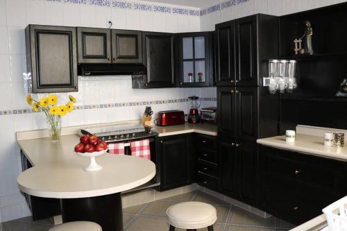 墨西哥城的住宿－Luxurious & Chic 2 BR Apt Polanquito Lincon Park，厨房配有黑色橱柜和一碗水果放在桌子上