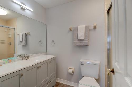 La salle de bains est pourvue de toilettes, d'un lavabo et d'un miroir. dans l'établissement Blue Skies Oceanfront 2 bedroom townhouse, à Ponce Inlet