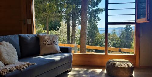 uma sala de estar com um sofá e uma grande janela em Casa Bosque em San Carlos de Bariloche