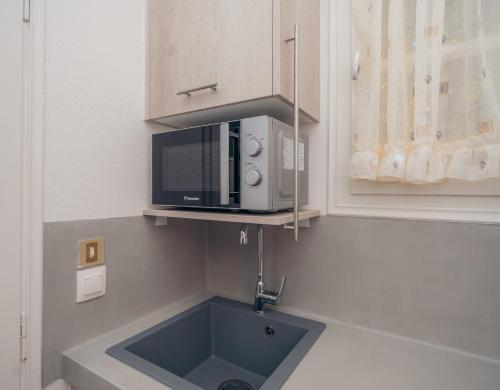 a microwave above a sink in a kitchen at Giannakas Studios in Platis Yialos Sifnos