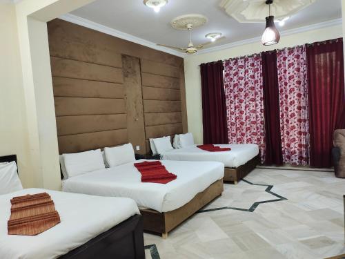 a hotel room with two beds and curtains at Casa Grande in Islamabad