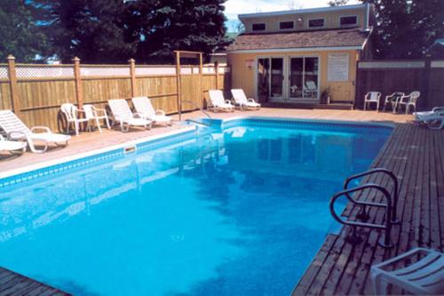 a large swimming pool with chairs at Shining Waters - Ingleside Cottages in Cavendish