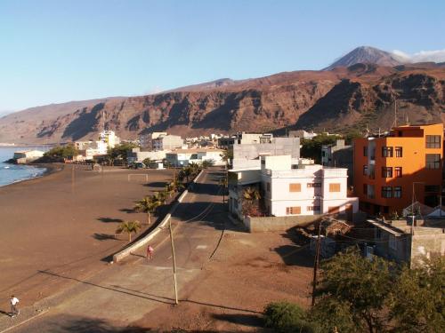 a city with a beach and mountains in the background at Edificio Magico in Tarrafal