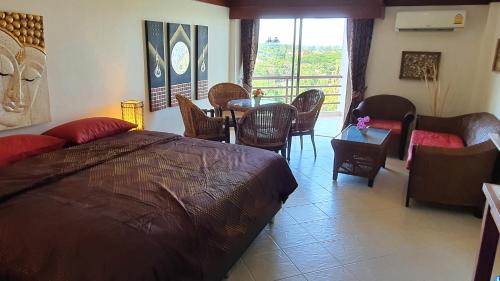 1 dormitorio con 1 cama, mesa y sillas en Double Superior Condo Rayong with seaview - 7th floor free wifi en Rayong