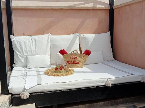 uma cama com almofadas brancas e um cartaz para venda em Dar al Sultan em Marrakech