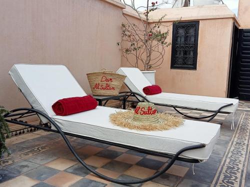 Duas cadeiras brancas sentadas em cima de um pátio em Dar al Sultan em Marrakech