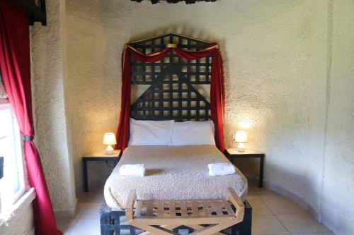een slaapkamer met een bed en 2 tafels met lampen bij Castillo Inspiracion Hostel in Bocas del Toro