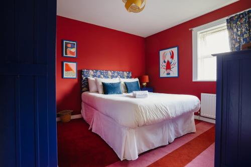 a bedroom with red walls and a large white bed at Central Belfast Apartments Unique Retreat in Belfast