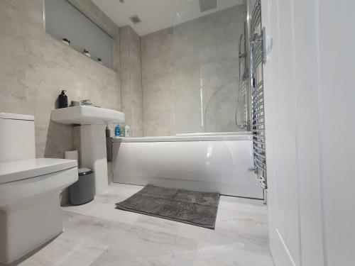 Ένα μπάνιο στο Lovely 2 - Cozy Retreat Modern 2-Bedroom Flat in Bedfordshire with Fully-Equipped Kitchen and Relaxing Living Space