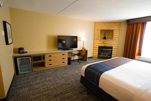 a hotel room with a bed and a desk with a television at Sawmill Creek by Cedar Point Resorts in Sandusky
