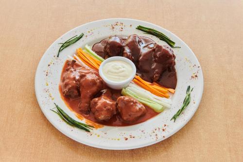 a plate of meatballs and vegetables with sauce on it at Best Western Plus Gran Hotel Centro Historico in Guadalajara