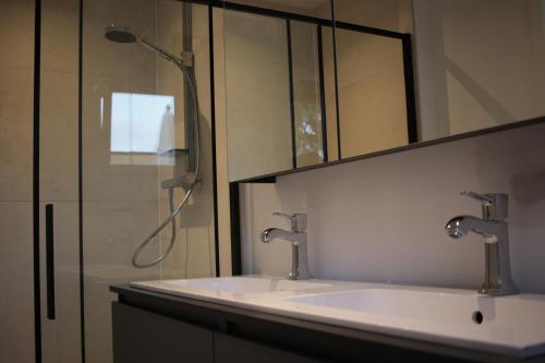 y baño con 2 lavabos y ducha. en The Suite Escape Apartment Sand, en Sint-Lievens-Houtem
