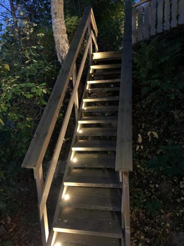 a wooden stairway with lights on it at Strandhytte in Kristiansand