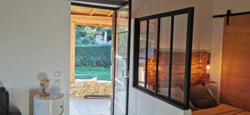 una puerta de cristal que conduce a un dormitorio con vistas en Le Pamaro en La Chapelle-dʼAurec