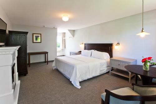 a bedroom with a large white bed and a table at The Seaglass Inn & Spa in Provincetown
