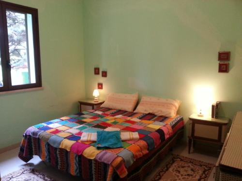 - une chambre avec un lit et une couverture colorée dans l'établissement Villa Sarmuci, Mare Natura Relax, à Scopello