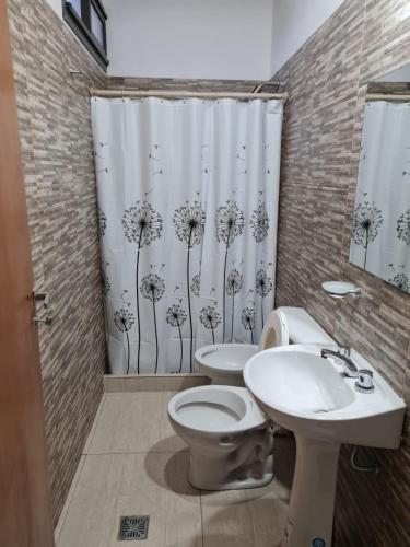 een badkamer met een toilet, een wastafel en een douchegordijn bij pedro de valdivia 219 in San Juan