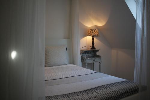 a bedroom with a bed and a lamp on a table at The Suite Escape Apartment Sand in Sint-Lievens-Houtem