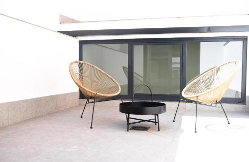 three chairs and a table on a patio at IMI Hotel & Spa in Ourense