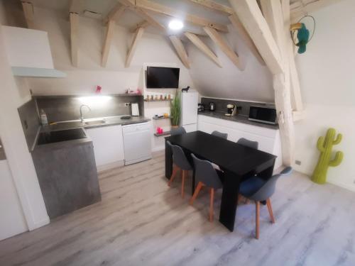 uma cozinha e sala de jantar com uma mesa preta e cadeiras em Au numéro 6 Le Fun em Châteauroux