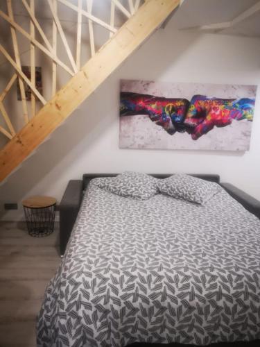 une chambre avec un lit et un tableau au mur dans l'établissement Au numéro 6 Le Fun, à Châteauroux