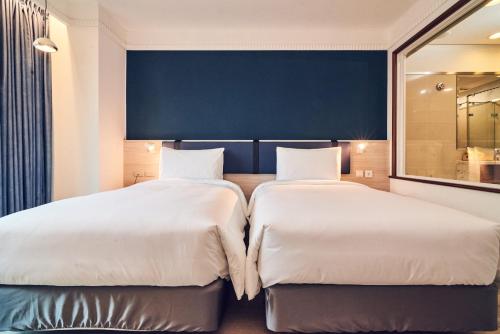 two beds sitting next to each other in a bedroom at CHECK inn Select Taipei Nangang in Taipei