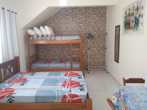 a bedroom with two bunk beds in a room at Quitinetes Canto Verde Caraguá in Caraguatatuba