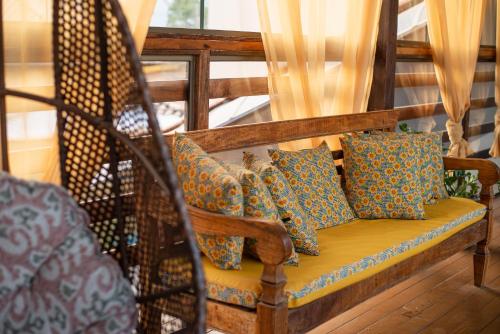 a wooden bench with pillows on a porch at Pousada Boa Vista in Tiradentes