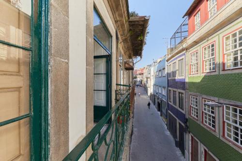 an alley with a dog walking down a street at A Portuguesa Guest House in Porto