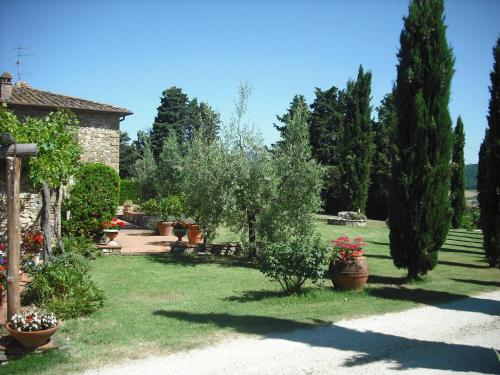 a garden with trees and potted plants and a house at Agriturismo La Scarpaia in Anghiari