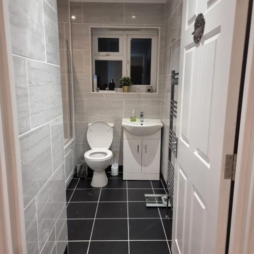 a bathroom with a toilet and a sink at One double room in A 4 bed in Enfield north London in Enfield Lock