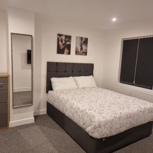 a bedroom with a large bed and a mirror at One double room in A 4 bed in Enfield north London in Enfield Lock