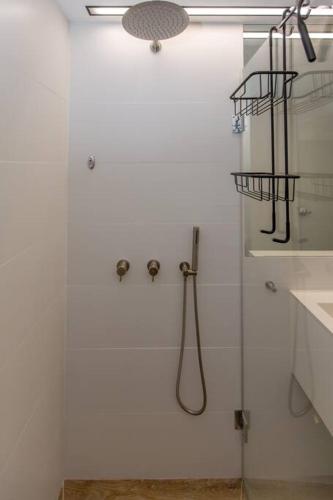 a white bathroom with a shower with a shower at Aphrodite Suite in Ashqelon