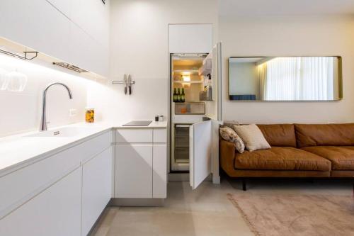 ein Wohnzimmer mit einem Sofa und einer Küche in der Unterkunft Aphrodite Suite in Aschkelon