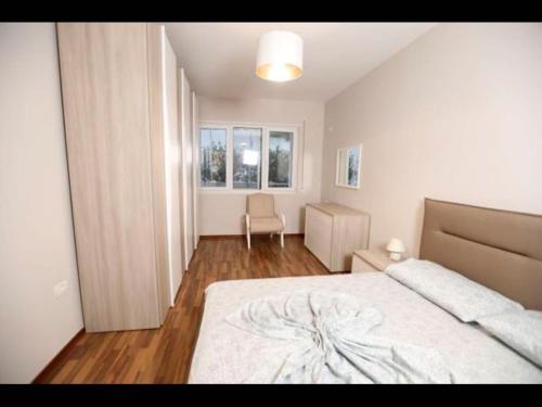 um quarto com uma cama e uma cadeira em Beachfront Sion Sarande Apartment 1 em Saranda