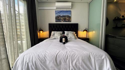 uma cama com um gato preto sentado em cima dela em Modern Luxury Studio with Breathtaking City Views - No Load Shedding na Cidade do Cabo