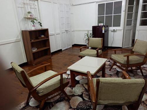 a living room with chairs and a table and a table and chairs at Casa Encanto Homestay in Shillong