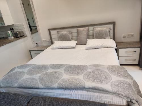 a bedroom with a large bed with a gray and white comforter at Hawana Salalah Laguna Studio in Salalah
