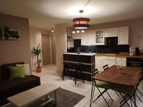 een keuken en een woonkamer met een tafel en een bank bij Ecully, appartement au calme de 50m². in Écully