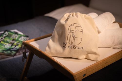 京都的住宿－INA HOUSE Nijojo，一张带毛巾的桌子上的一个袋子