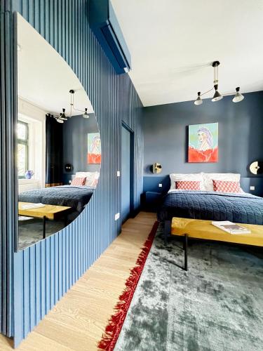 two beds in a room with blue walls at Sissi West in Vienna