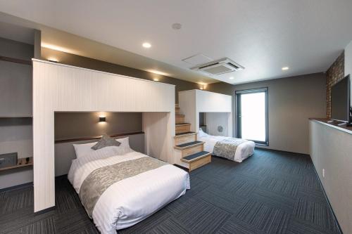 una camera d'albergo con due letti e una scala di ＥＮＴ ＴＥＲＲＡＣＥ ＡＳＡＫＵＳＡ - Vacation STAY 85544v a Tokyo