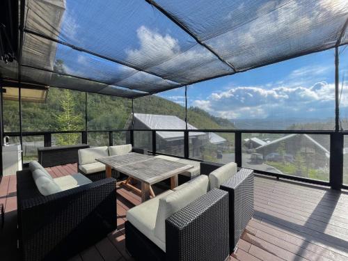 a balcony with a table and chairs and a view at Asama Kuzanbo in Naganohara