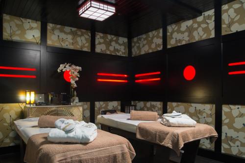a room with two beds and red lights on the wall at Holyrood Hotel - Leisure Centre & The Spa at Orchids in Bundoran