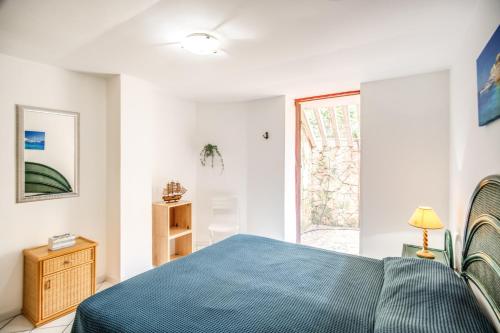 a bedroom with a blue bed and a window at Emerald Holiday House in Marina di Mancaversa