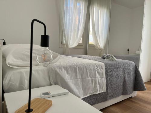 a bedroom with a bed and a table with a lamp at Ca' Yvonne alloggio a Lido di Venezia in Venice-Lido