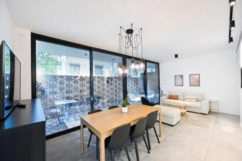 a dining room with a table and chairs and a couch at Black Panter by HolyGuest in Tel Aviv