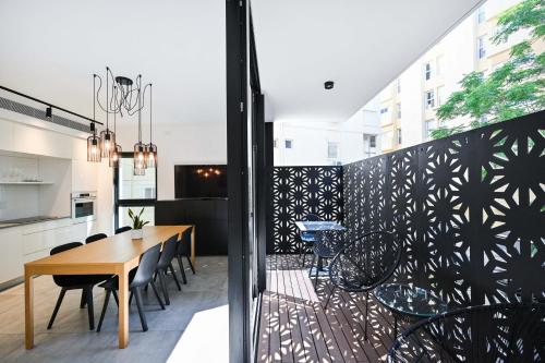 a dining room with a table and chairs on a balcony at Black Panter by HolyGuest in Tel Aviv
